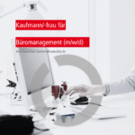 Ein Kaufmann für Büromanagement arbeitet an seinem Schreibtisch.